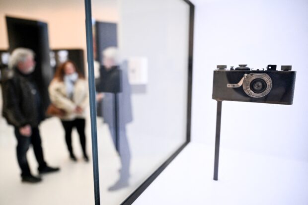 The first Leica camera from 1925 is pictured on the historical stand at the Leica factory in Wetzlar, western Germany, on March 18, 2025. Born in Wetzlar, in central Germany, the brand with the red dot still fascinates and asserts its niche position in a market dominated by Japanese giants such as Sony, Canon and Nikon. Although the Leica optics and microscope manufacturing company was founded in 1869 by entrepreneur Ernst Leitz, it was in 1925 that it presented its first 35mm camera model, which laid the foundations for modern photography. (Photo by Kirill KUDRYAVTSEV / AFP) / TO GO WITH AFP STORY BY JEAN-PHILLIPPE LACOUR