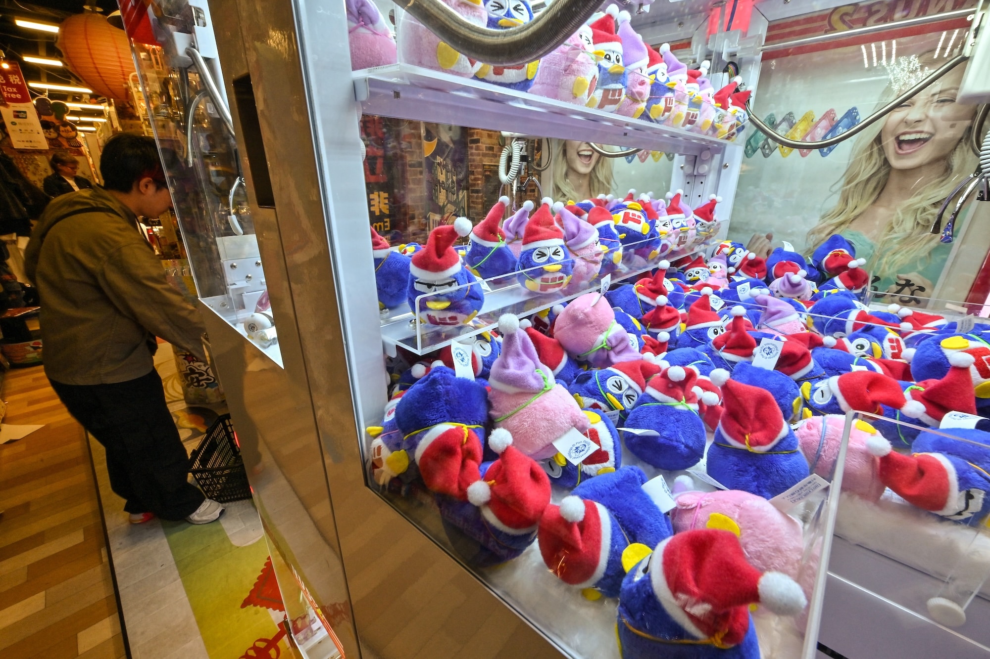 This photo taken on April 21, 2025 shows a machine selling little versions of "Donpen", the official character of Japanese discount retailer Don Quijote, also known overseas as Don Don Donki, at one of their branches in the Shibuya district of central Tokyo. In the narrow, crowded aisles of a department store in Tokyo's Shibuya district, hundreds of tourists rush to fill their baskets with snacks, gadgets, and souvenirs of all kinds, fuelling sales at Don Quijote, the king of Japanese discount stores. (Photo by Richard A. Brooks / AFP) / TO GO WITH AFP STORY JAPAN-TOURISM-ECONOMY-RETAIL,FOCUS BY CAROLINE GARDIN AND ATISH PATEL